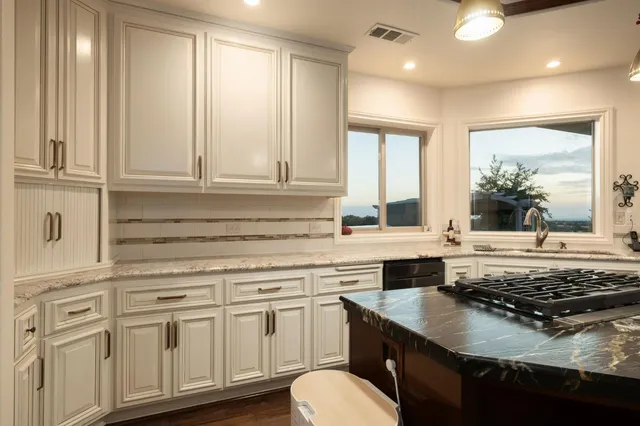 a kitchen with a stove a sink and a window
