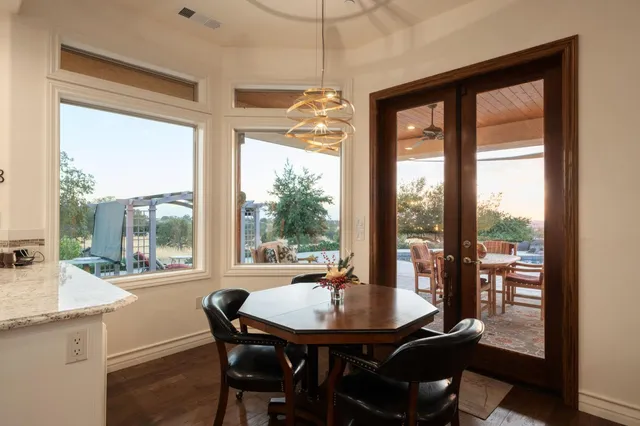 a view of a dining room with furniture large windows and wooden floor