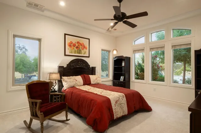 a bedroom with a bed dresser and a large window