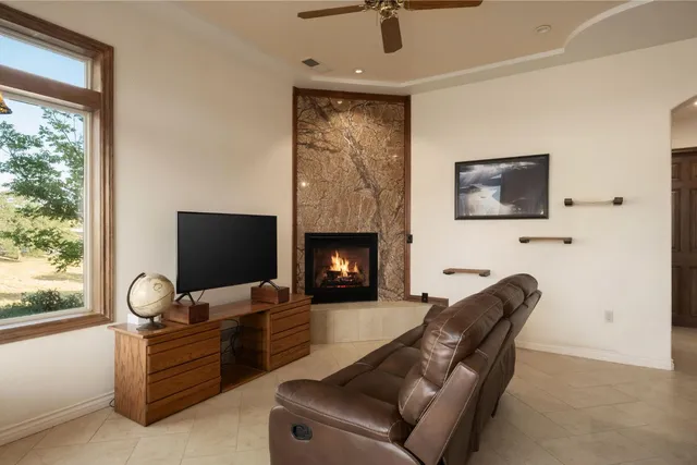 a living room with furniture a flat screen tv and a fireplace