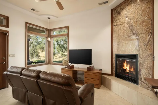 a living room with furniture a fireplace and a flat screen tv