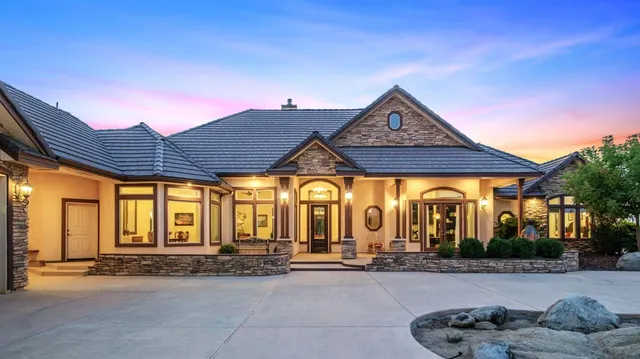 a view of a house with large windows and a table and chairs
