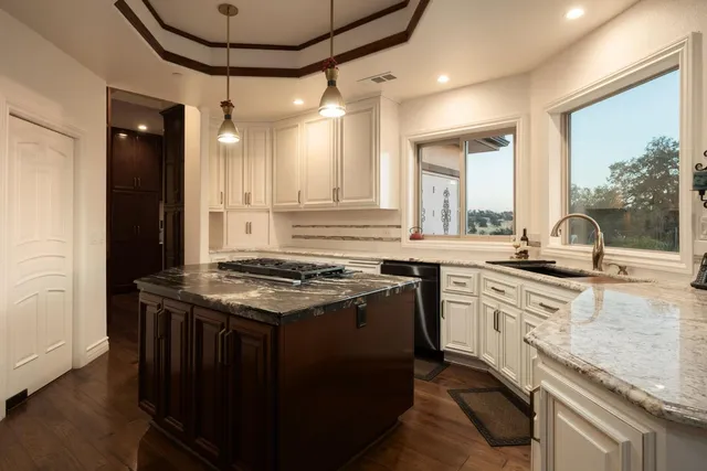 a kitchen with stainless steel appliances granite countertop a stove and a sink