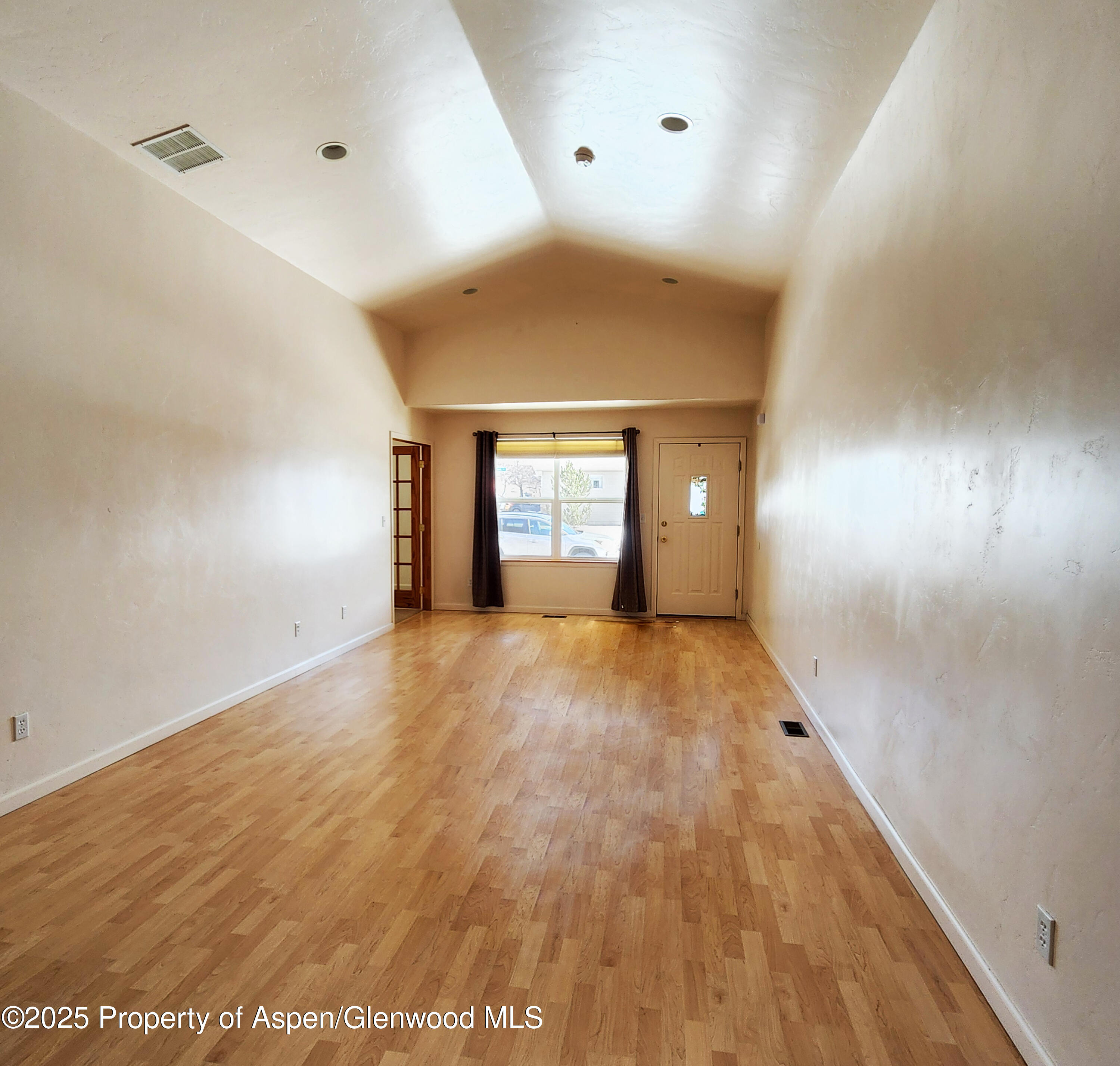 1695 Arabian Avenue Rifle, CO 81650 - Photo 6 of 20 a view of an empty room with window and wooden floor
