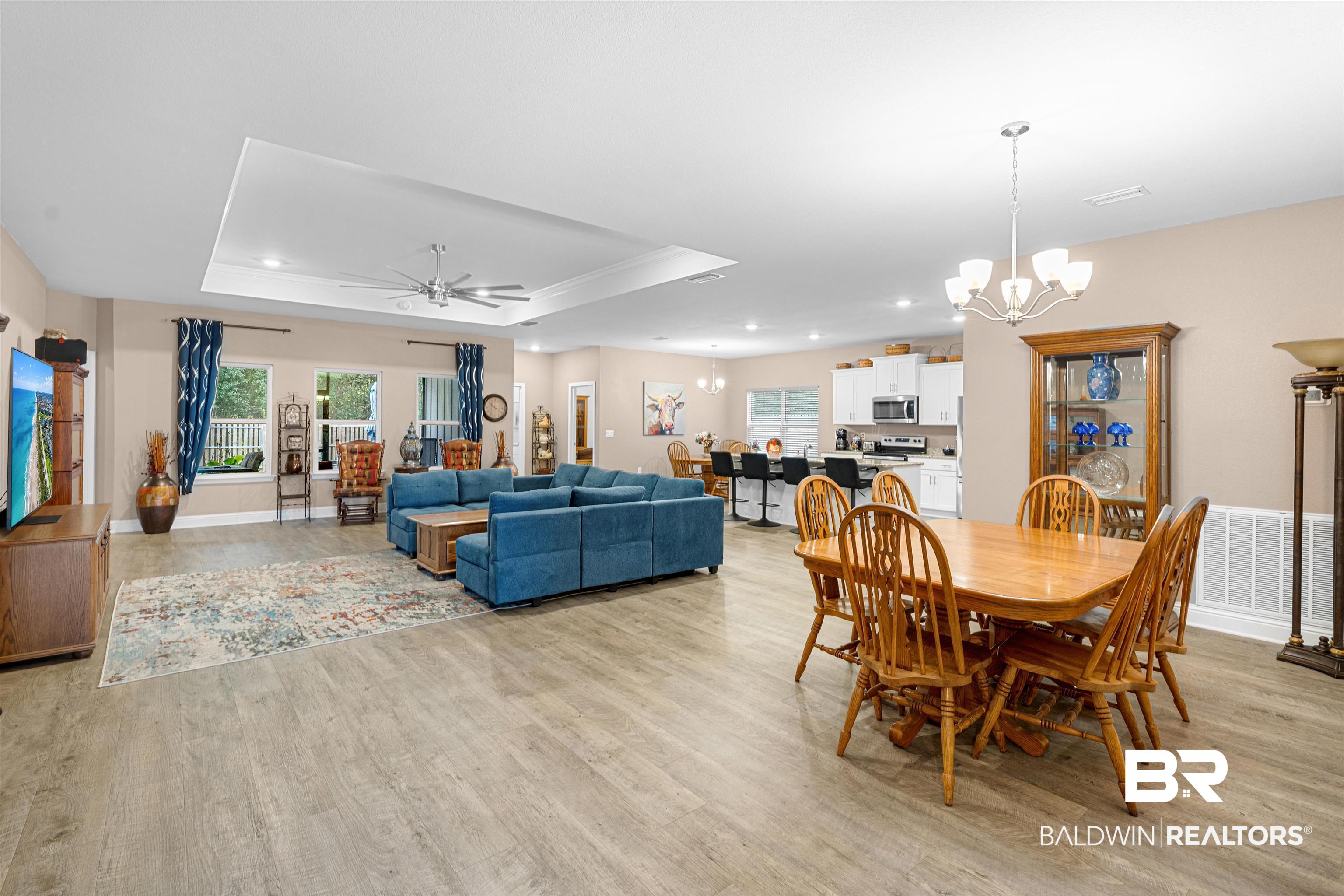 697 Calibre Street Fairhope, AL 36532 - Photo 8 of 18 Dining room featuring ceiling fan, light wood-type flooring, hanging lights, a tray ceiling, and crown molding