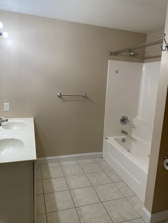 a bathroom with a bathtub a sink a toilet and a mirror