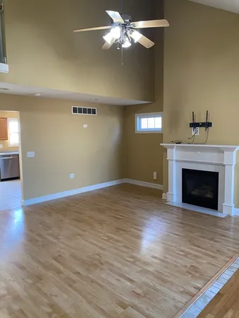 a view of empty room with wooden floor and fireplace