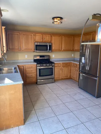 a kitchen with stainless steel appliances granite countertop a refrigerator and a stove top oven