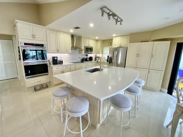 a kitchen with stainless steel appliances a dining table and chairs