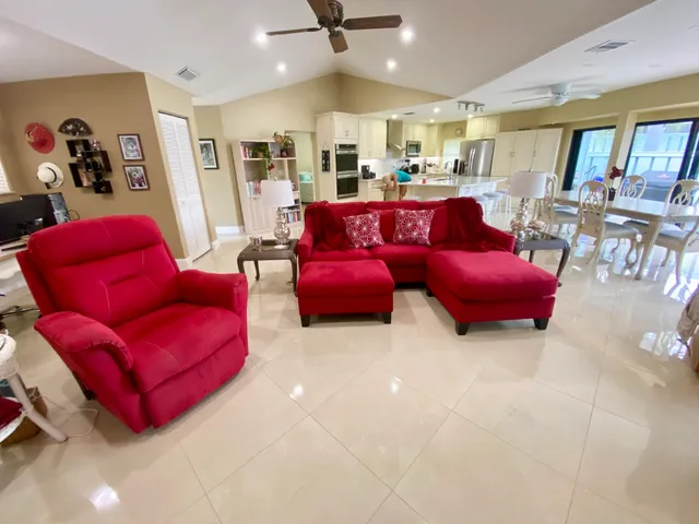 a living room with furniture kitchen view and a large window