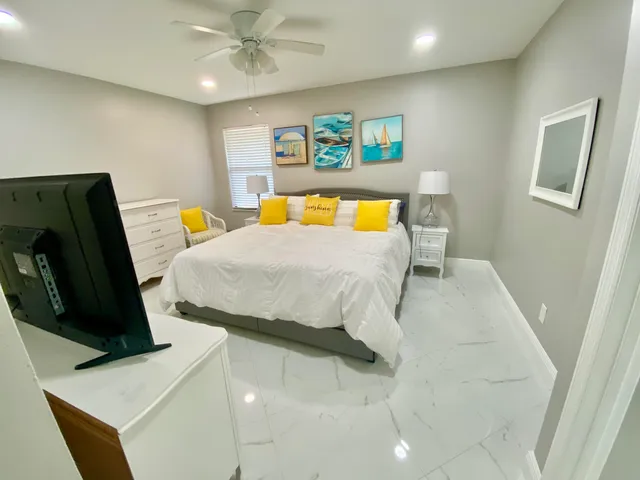 a bedroom with a bed a couch and paintings on the wall