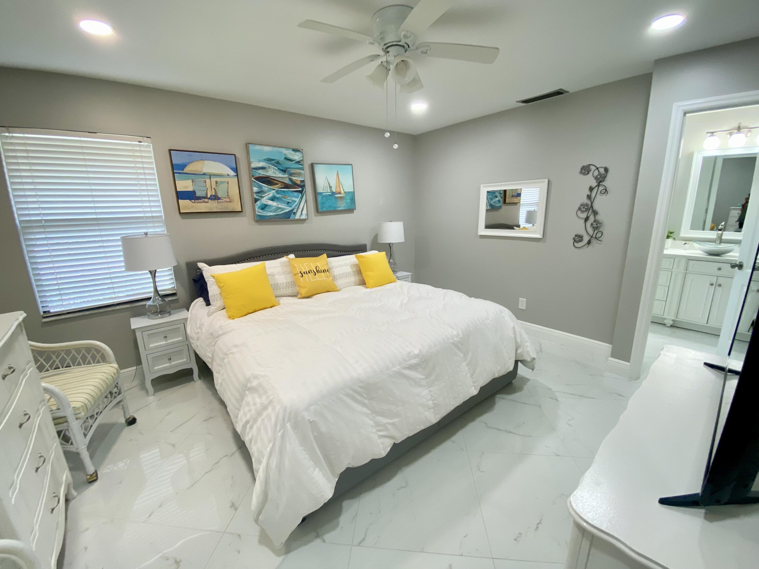 1127 East Seminole Avenue, Unit 13D Jupiter, FL 33477 - Photo 8 of 20 a bedroom with a bed and painting on the wall