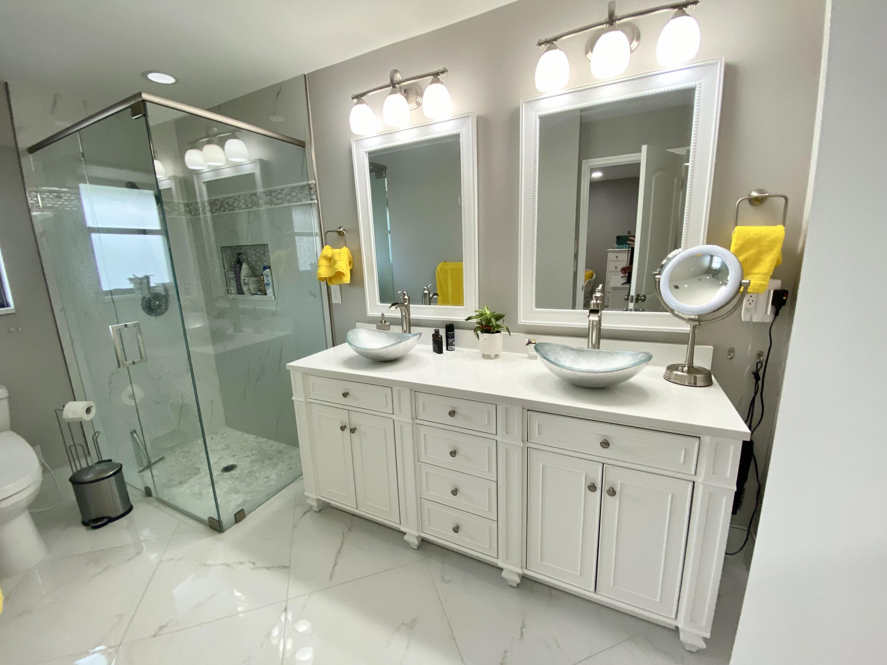 1127 East Seminole Avenue, Unit 13D Jupiter, FL 33477 - Photo 9 of 20 a spacious bathroom with double sink and a mirror
