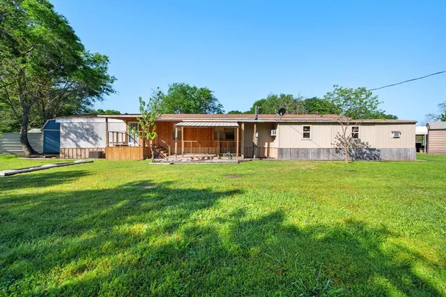 a view of a house with backyard and sitting area