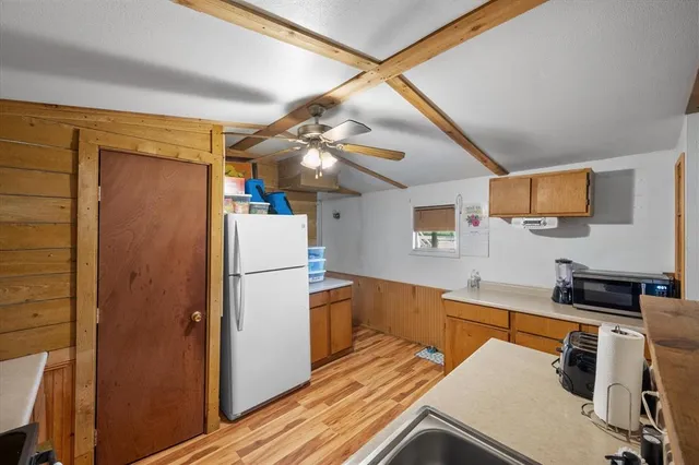 a kitchen with a refrigerator and a stove top oven