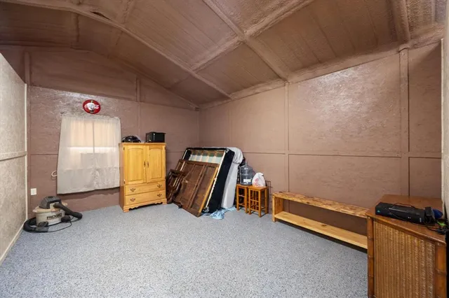 a backyard of a house with table and chairs under an umbrella
