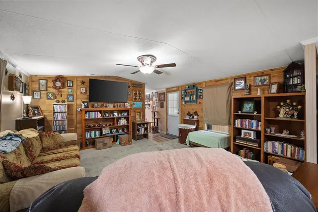 a spacious bedroom with a bed a dresser and a book shelf