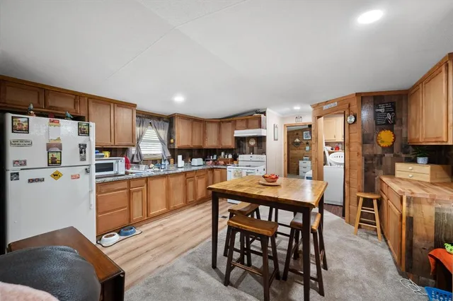 a kitchen with stainless steel appliances wooden floor and large windows