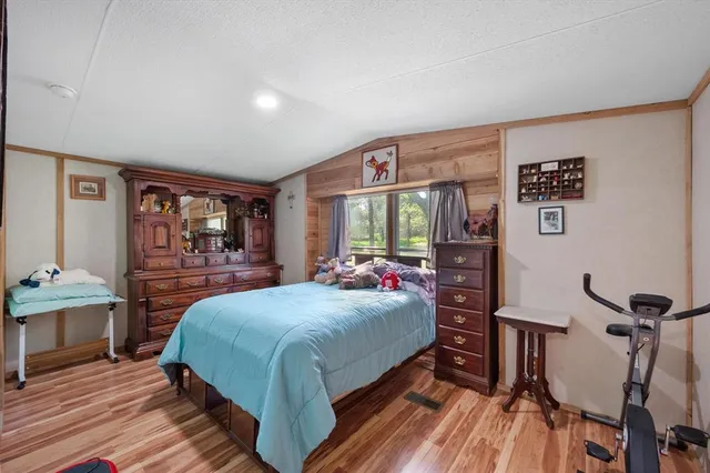 a bedroom with a bed and wooden floor