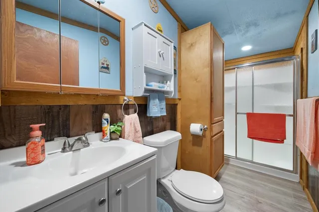 a bathroom with a sink a toilet and shower