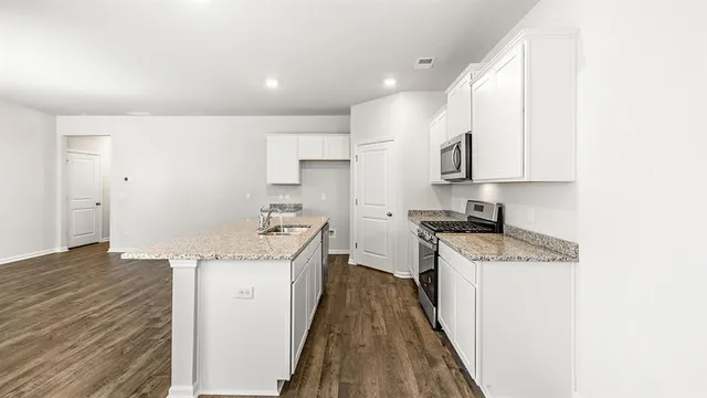 a kitchen with a sink stove and cabinets