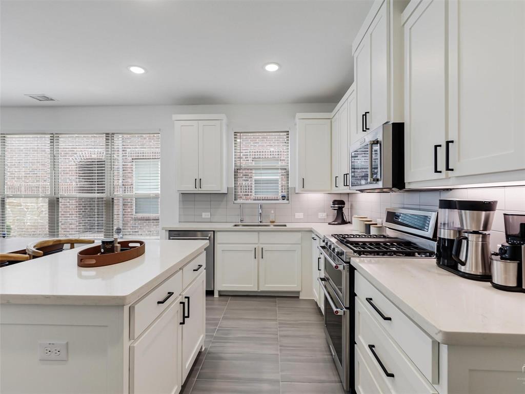 5912 Ridgeline Drive McKinney, TX 75070 - Photo 10 of 22 a kitchen with a stove sink and cabinets