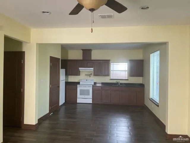 a kitchen with stainless steel appliances kitchen island granite countertop a stove a sink and a refrigerator