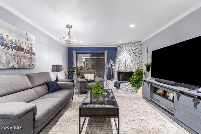 a living room with furniture a flat screen tv and a chandelier