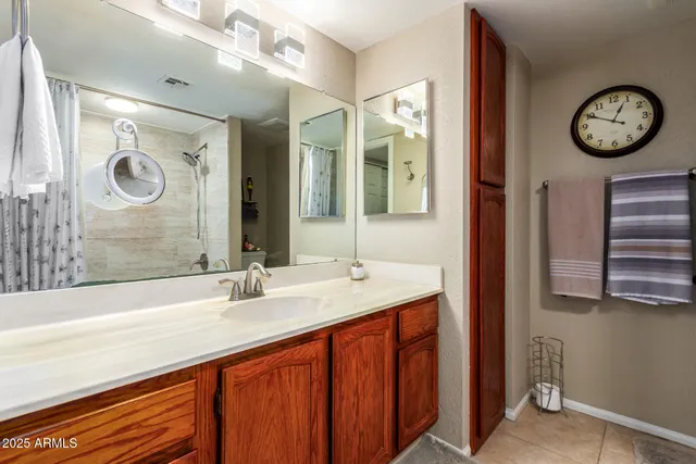 a bathroom with a granite countertop sink and a large mirror