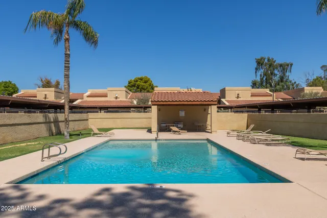 a view of a house with pool and chairs