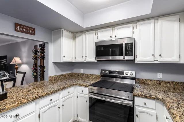 a kitchen with granite countertop a sink and cabinets