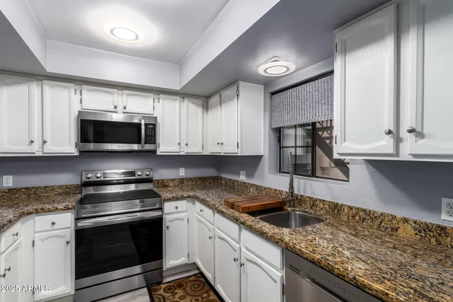 a kitchen with stainless steel appliances granite countertop a sink stove and microwave