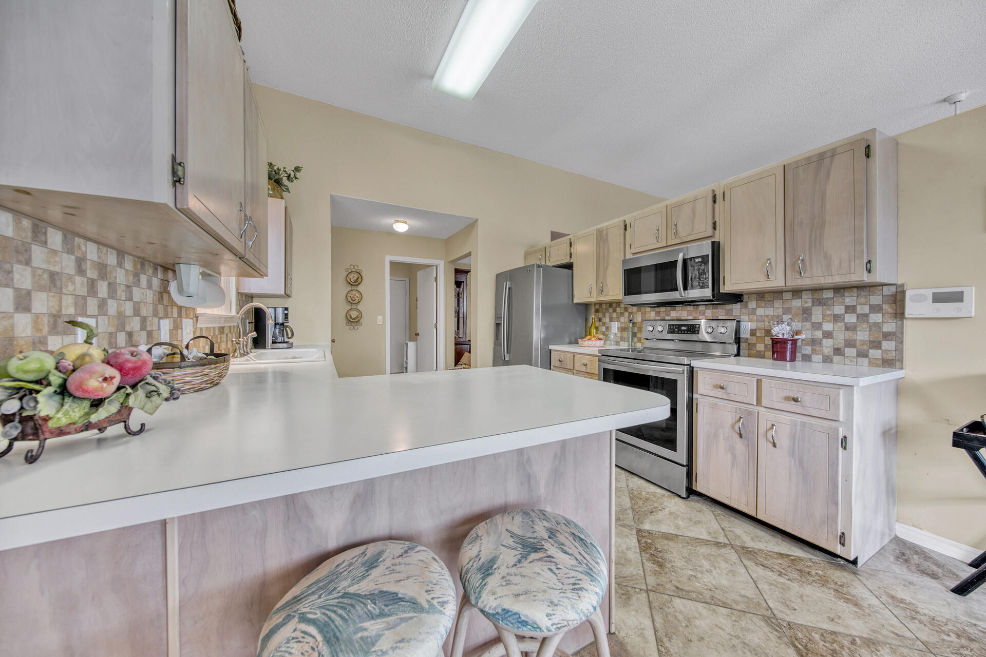 3789 Misty Way Destin, FL 32541 - Photo 11 of 29 a kitchen with stainless steel appliances kitchen island granite countertop a sink dishwasher and white cabinets with wooden floor