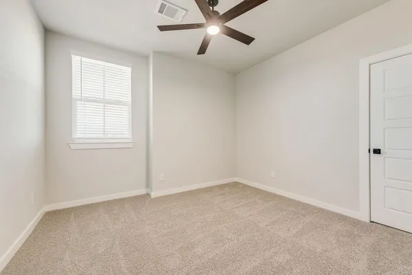 an empty room with a window and a fan