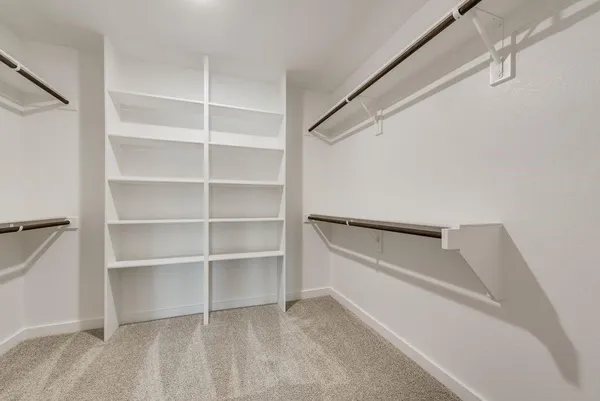 a view of walk in closet with empty racks
