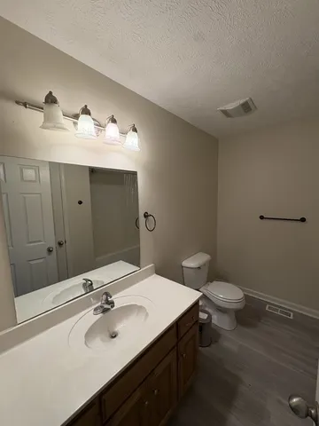 a bathroom with a sink toilet and mirror