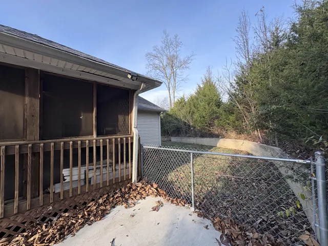 a view of a yard with wooden fence
