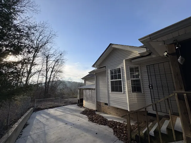 a view of a house with backyard and trees
