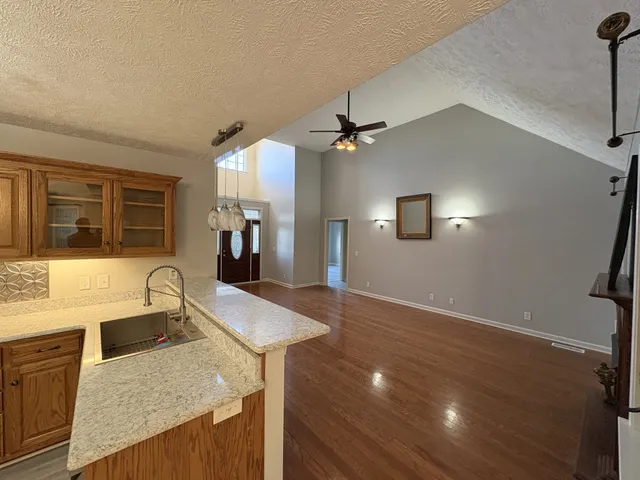 a kitchen with granite countertop a sink a counter top space and stainless steel appliances