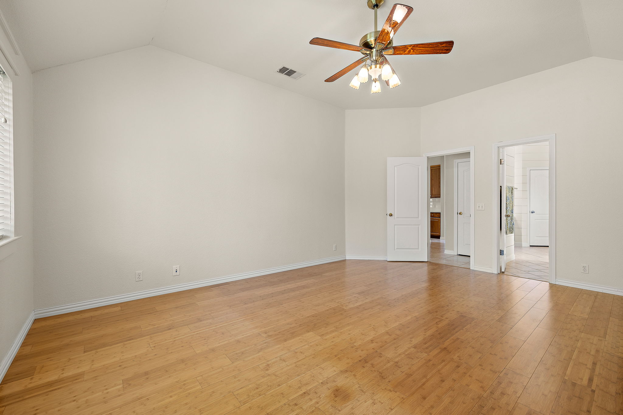 1102 Nelson Ranch Road Cedar Park, TX 78613 - Photo 22 of 37 A spacious primary bedroom features rich hardwood flooring and a vaulted ceiling with a classic ceiling fan.
