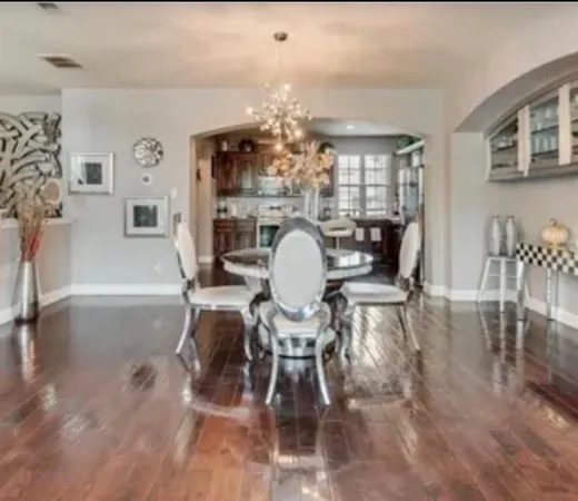 a dining room with furniture a chandelier and wooden floor