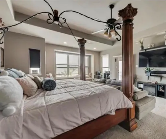 a bedroom with a bed window and a flat screen tv