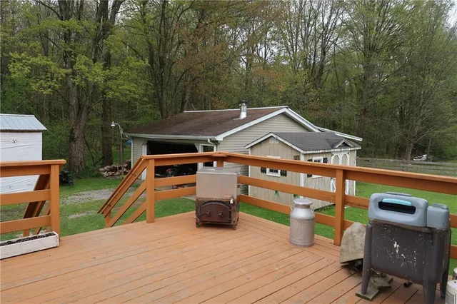 a view of a roof deck with table and chairs a barbeque with wooden floor and fence