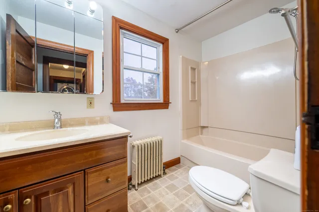 a bathroom with a granite countertop toilet sink and mirror