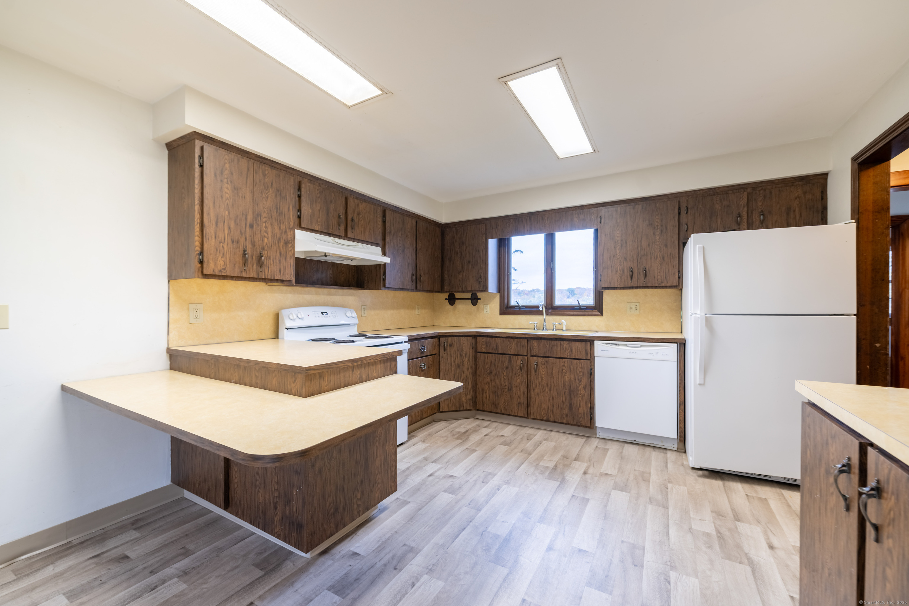 23 Waldo Road Norwich, CT 06360 - Photo 4 of 26 a kitchen with a refrigerator a sink dishwasher and a stove with wooden floor