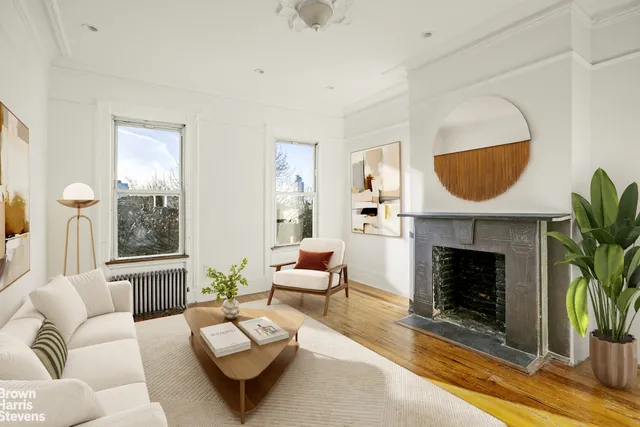 a living room with furniture a fireplace and a potted plant
