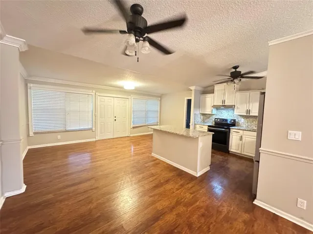 a large kitchen with cabinets wooden floor and stainless steel appliances