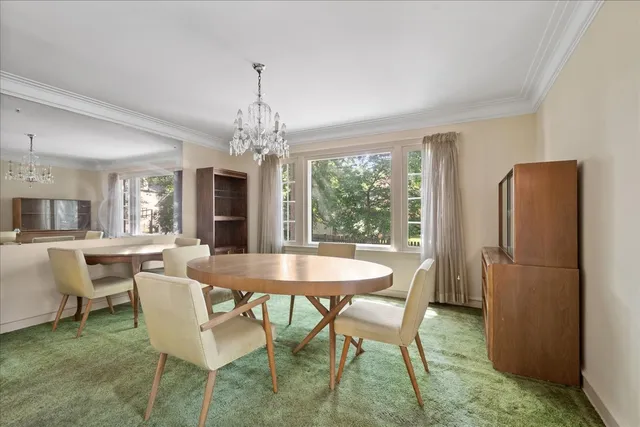 a dining room with furniture a chandelier and wooden floor