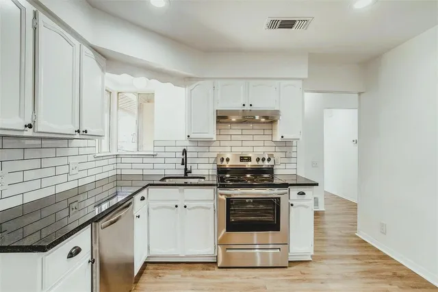 a kitchen with stainless steel appliances granite countertop a stove and a sink