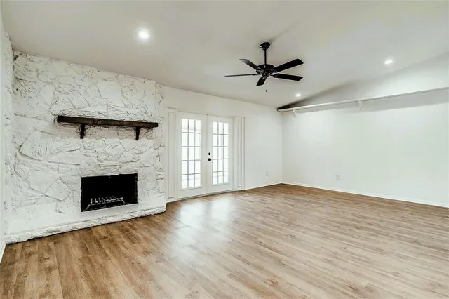 an empty room with windows and fireplace